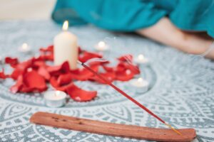 Burning incense red stick on candles background and woman practicing yoga